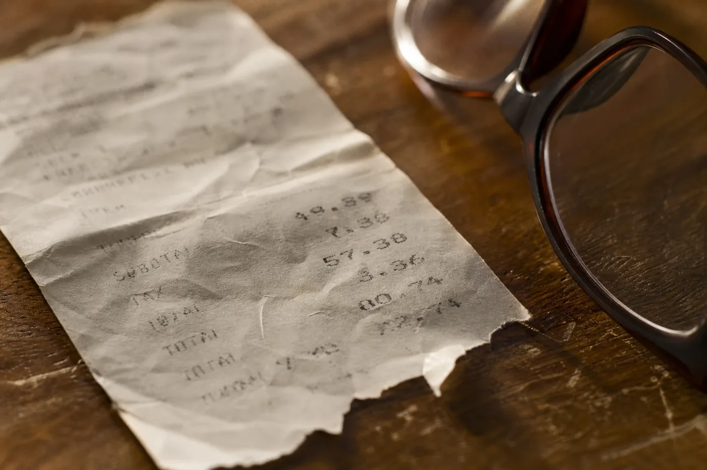 Extreme close-up of a crumpled thermal receipt with smudged, hard-to-read numbers