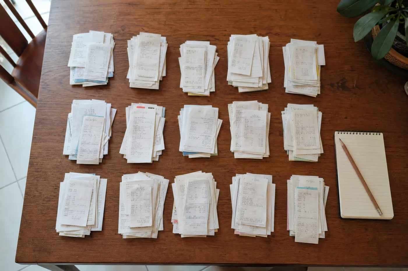 A month’s worth of receipts sorted into neat piles on a dining table